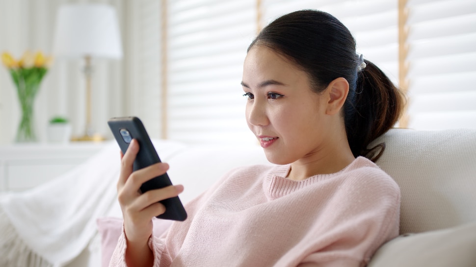 Young woman looking at her phone, on social media